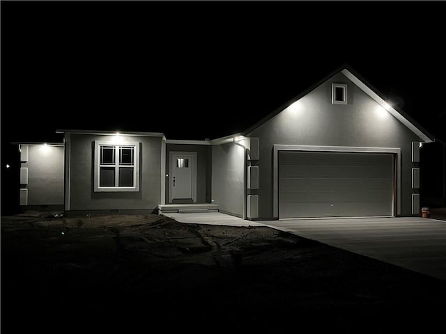 407 N Harmon St, Girard, KS 66743 - ranch-style home featuring stucco siding, an attached garage, and driveway