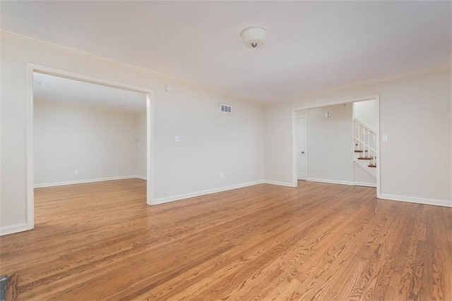 627 E Meyer Blvd, Kansas City, MO 64131 - unfurnished room with stairway, light wood finished floors, and ornamental molding