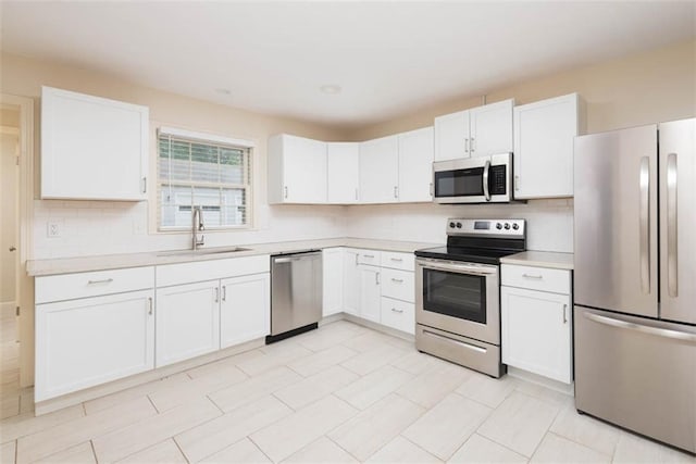 627 E Meyer Blvd, Kansas City, MO 64131 - kitchen featuring stainless steel appliances, light countertops, backsplash, and white cabinets