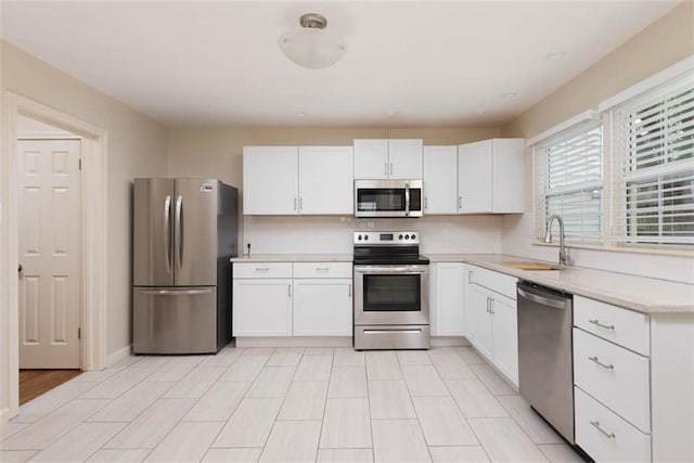627 E Meyer Blvd, Kansas City, MO 64131 - kitchen featuring appliances with stainless steel finishes, white cabinets, and backsplash