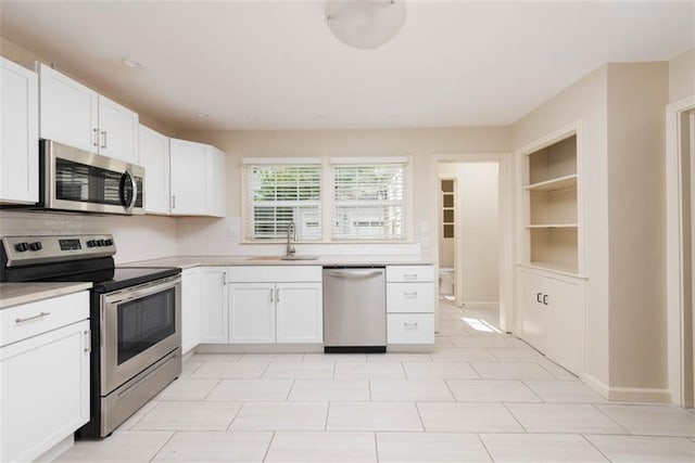 627 E Meyer Blvd, Kansas City, MO 64131 - kitchen with stainless steel appliances, light countertops, white cabinetry, and backsplash