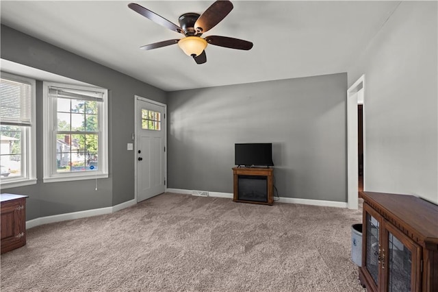 8315 Laurel Ave, Raytown, MO 64138 - unfurnished living room with ceiling fan and light colored carpet