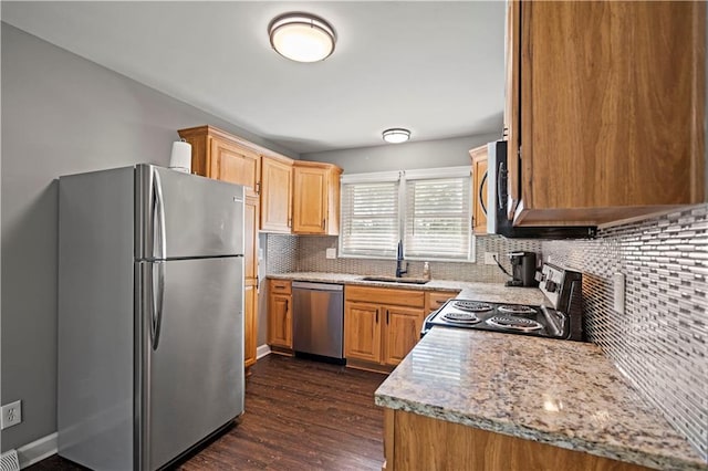 8315 Laurel Ave, Raytown, MO 64138 - kitchen with stainless steel appliances, backsplash, dark wood-type flooring, and light stone counters