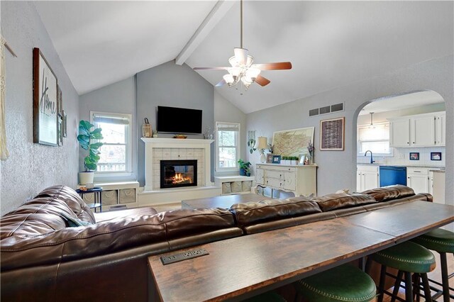 1211 SW Walnut St, Lees Summit, MO 64081 - living room featuring ceiling fan, arched walkways, a fireplace, and plenty of natural light