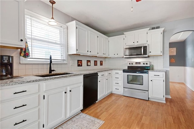1211 SW Walnut St, Lees Summit, MO 64081 - kitchen featuring stainless steel microwave, range with electric cooktop, dishwasher, arched walkways, and white cabinetry
