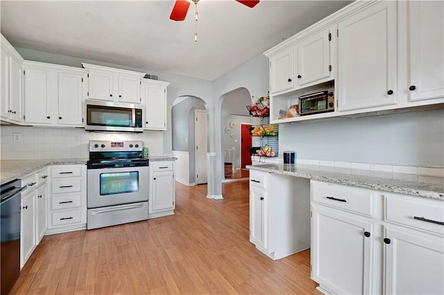 1211 SW Walnut St, Lees Summit, MO 64081 - kitchen featuring appliances with stainless steel finishes, arched walkways, a ceiling fan, white cabinets, and light wood-style floors