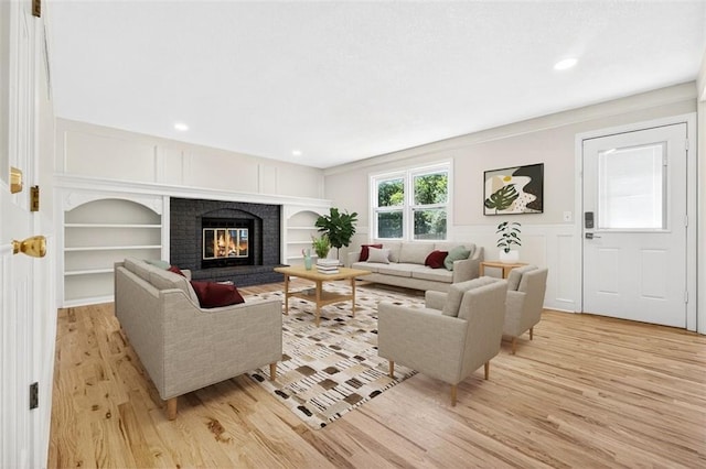 2623 W 131st St, Olathe, KS 66061 - living room with a decorative wall, light wood-style floors, built in features, a wainscoted wall, and recessed lighting