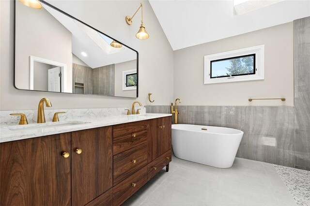 2623 W 131st St, Olathe, KS 66061 - bathroom featuring double vanity, lofted ceiling, a soaking tub, a skylight, and tile patterned floors