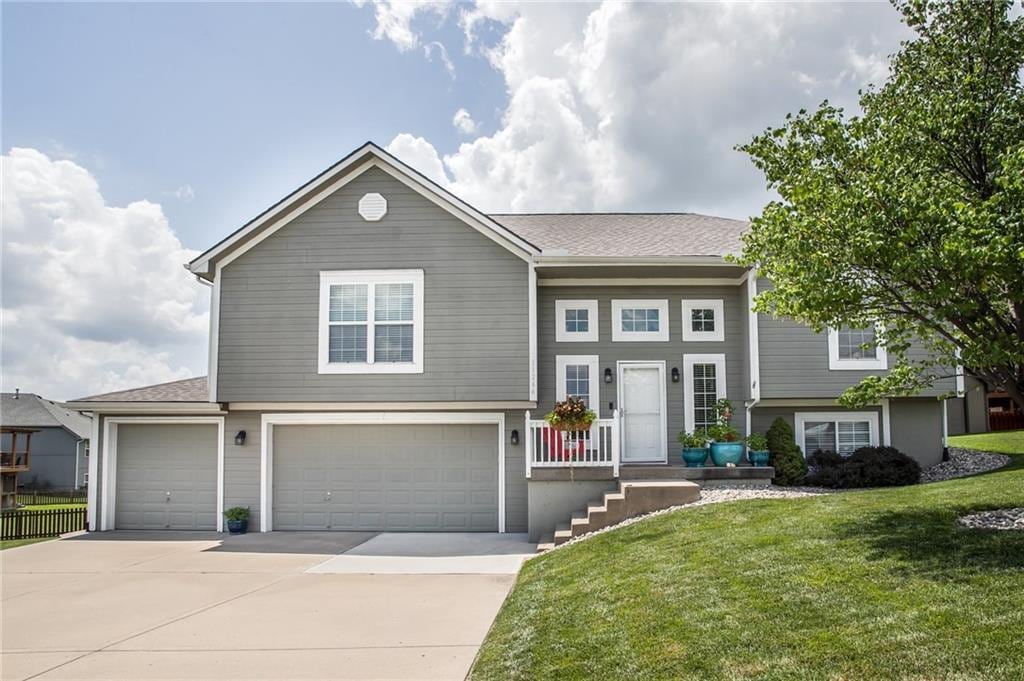 11264 N Jarboe St, Kansas City, MO 64155 - split level home featuring concrete driveway and an attached garage