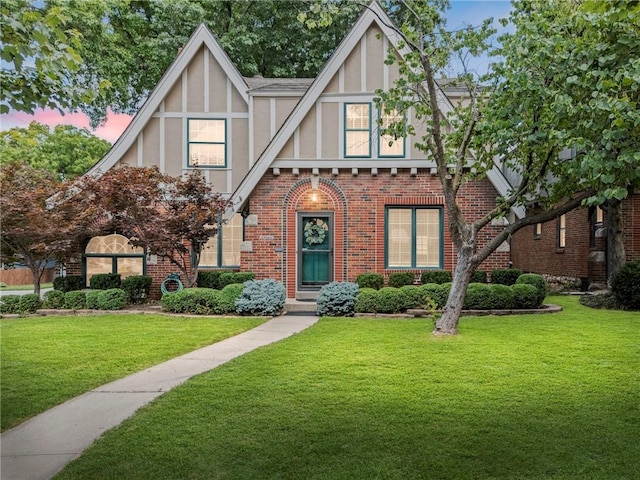 1296 W 72nd Ter, Kansas City, MO 64114 - tudor-style house featuring stucco siding, a front yard, and brick siding