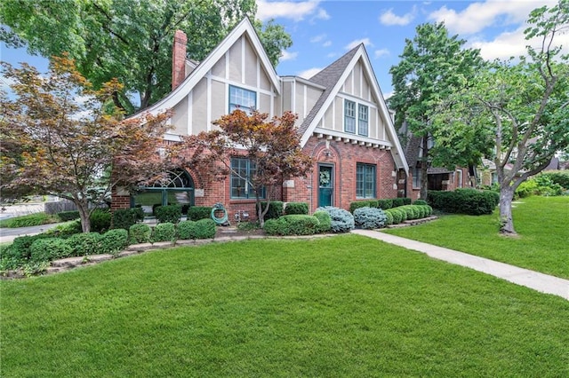 1296 W 72nd Ter, Kansas City, MO 64114 - tudor-style house with brick siding, a front lawn, stucco siding, and a chimney