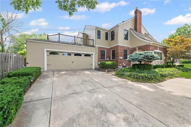 1296 W 72nd Ter, Kansas City, MO 64114 - view of front of house with a balcony, an attached garage, driveway, brick siding, and a chimney