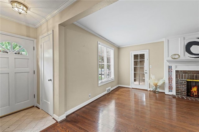 1296 W 72nd Ter, Kansas City, MO 64114 - entrance foyer with wood finished floors, ornamental molding, and a brick fireplace