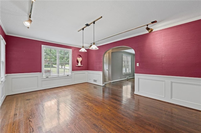 1296 W 72nd Ter, Kansas City, MO 64114 - unfurnished room with track lighting, arched walkways, crown molding, a wainscoted wall, and wood finished floors