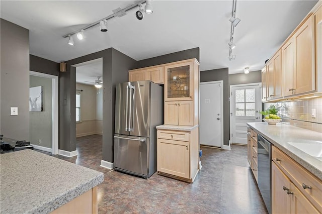 1296 W 72nd Ter, Kansas City, MO 64114 - kitchen featuring appliances with stainless steel finishes, light brown cabinets, track lighting, glass insert cabinets, and light countertops