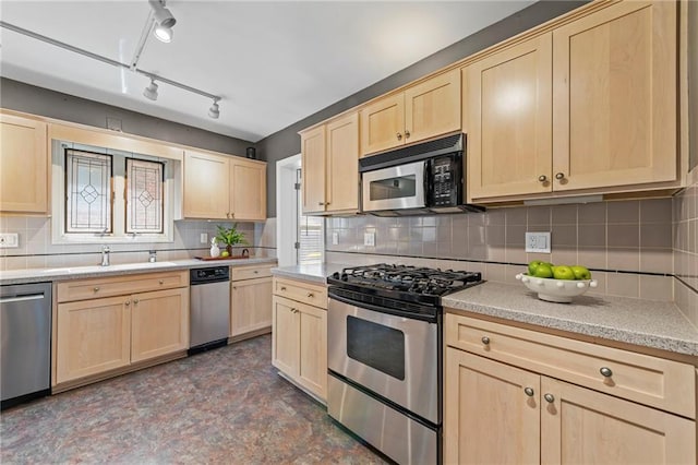 1296 W 72nd Ter, Kansas City, MO 64114 - kitchen featuring light brown cabinetry, stainless steel appliances, backsplash, and track lighting