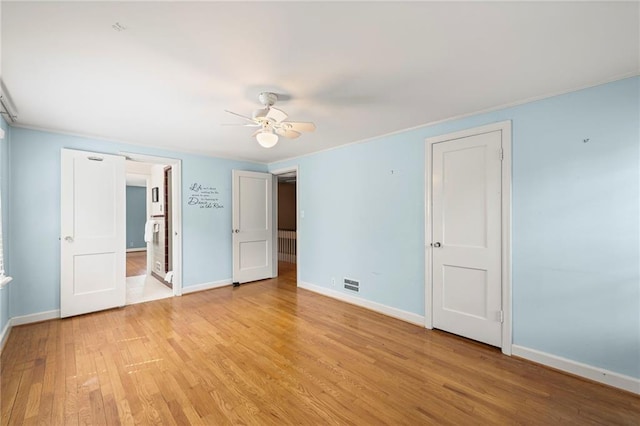 1296 W 72nd Ter, Kansas City, MO 64114 - unfurnished bedroom featuring light wood-style flooring, connected bathroom, and a ceiling fan