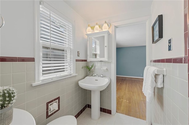 1296 W 72nd Ter, Kansas City, MO 64114 - half bathroom with tile walls, wainscoting, and tile patterned floors