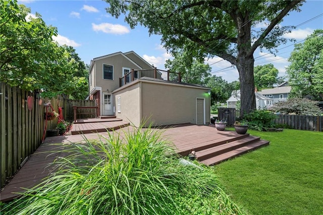 1296 W 72nd Ter, Kansas City, MO 64114 - back of property featuring a balcony, stucco siding, a fenced backyard, and a wooden deck