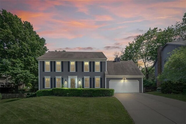 12147 Farley St, Overland Park, KS 66213 - colonial house featuring driveway, an attached garage, and a front lawn