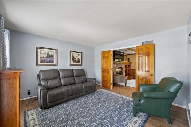 12147 Farley St, Overland Park, KS 66213 - living area featuring a brick fireplace and wood finished floors