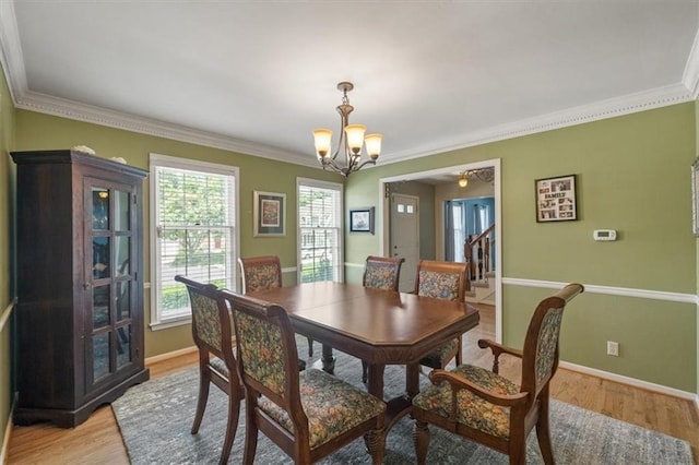 12147 Farley St, Overland Park, KS 66213 - dining space with a chandelier, crown molding, light wood-style floors, and stairs