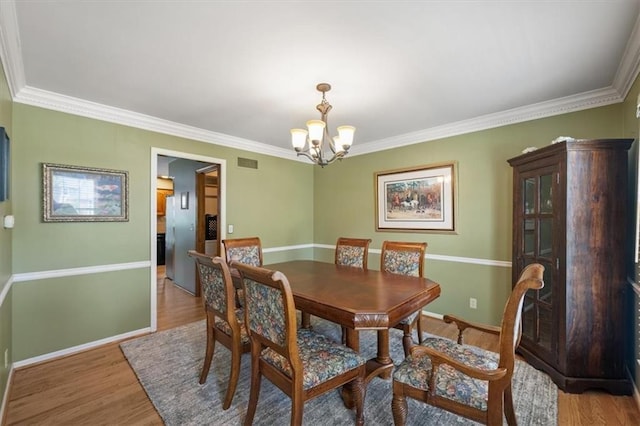 12147 Farley St, Overland Park, KS 66213 - dining area with a chandelier, light wood finished floors, and ornamental molding