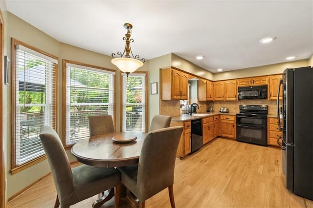 12147 Farley St, Overland Park, KS 66213 - kitchen featuring black appliances, light wood finished floors, backsplash, brown cabinetry, and recessed lighting
