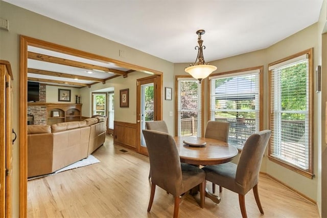 12147 Farley St, Overland Park, KS 66213 - dining room with light wood-type flooring, healthy amount of natural light, a wainscoted wall, and beamed ceiling