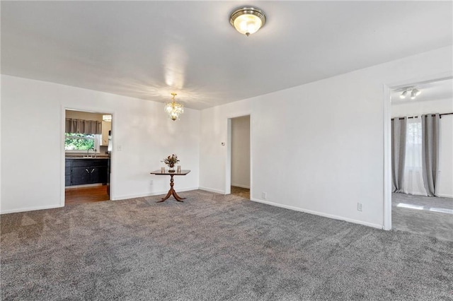 811 S Hickory St, Ottawa, KS 66067 - carpeted empty room featuring a chandelier and plenty of natural light