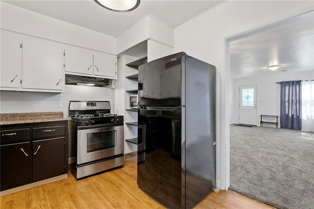 811 S Hickory St, Ottawa, KS 66067 - kitchen with stainless steel range with gas cooktop, freestanding refrigerator, under cabinet range hood, white cabinetry, and tasteful backsplash