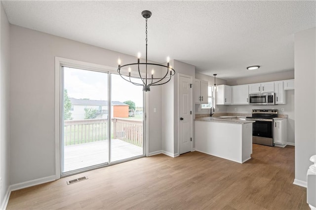 32625 W 174th St, Gardner, KS 66030 - kitchen featuring appliances with stainless steel finishes, a chandelier, light wood-type flooring, white cabinetry, and a peninsula