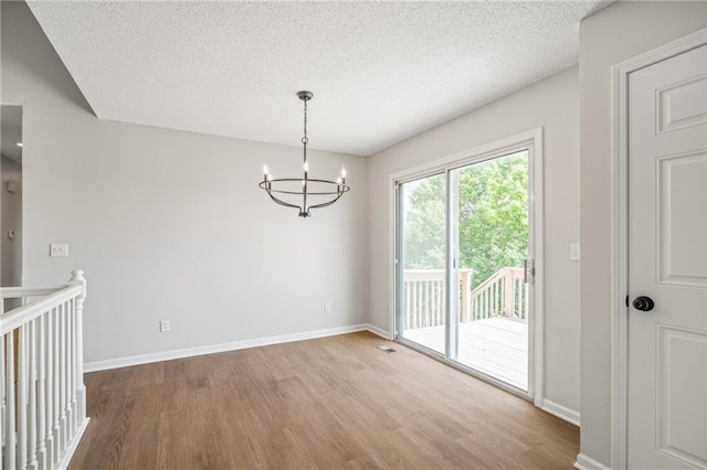 32625 W 174th St, Gardner, KS 66030 - unfurnished dining area featuring wood finished floors, a chandelier, and a textured ceiling