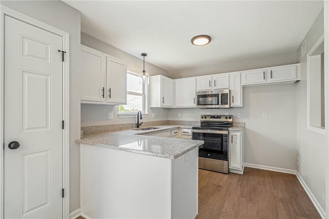 32625 W 174th St, Gardner, KS 66030 - kitchen with appliances with stainless steel finishes, white cabinets, a peninsula, wood finished floors, and pendant lighting
