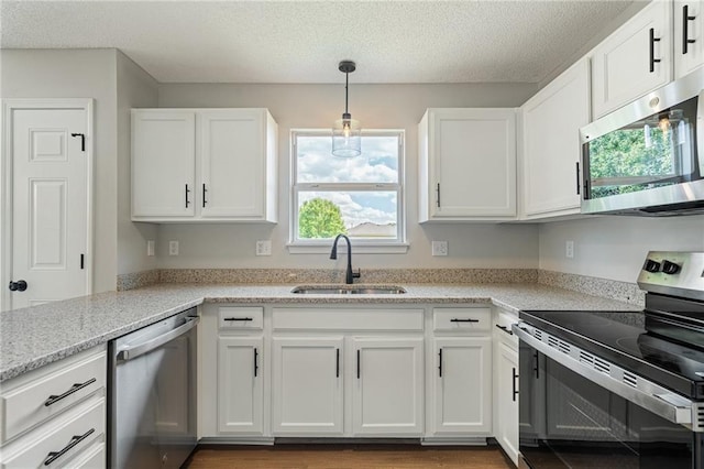 32625 W 174th St, Gardner, KS 66030 - kitchen with stainless steel appliances, white cabinets, a textured ceiling, decorative light fixtures, and light stone countertops
