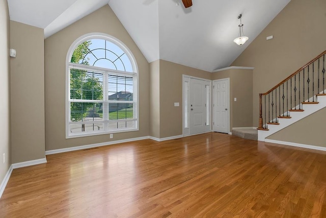 701 Tomahawk Ct, Smithville, MO 64089 - foyer featuring light wood-style flooring, a ceiling fan, high vaulted ceiling, and stairway