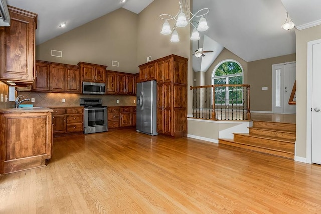 701 Tomahawk Ct, Smithville, MO 64089 - kitchen featuring appliances with stainless steel finishes, light wood finished floors, high vaulted ceiling, a ceiling fan, and tasteful backsplash