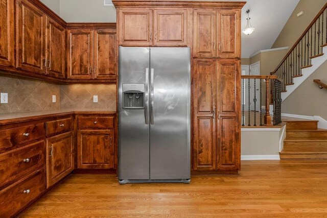 701 Tomahawk Ct, Smithville, MO 64089 - kitchen featuring stainless steel refrigerator with ice dispenser, tasteful backsplash, light wood-style floors, and brown cabinets