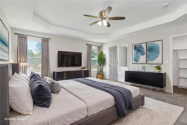 18201 W 157th Ter, Olathe, KS 66062 - carpeted bedroom with a tray ceiling, multiple windows, and ceiling fan