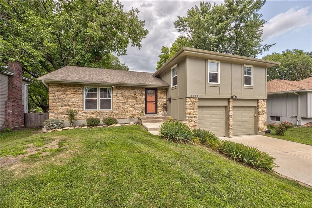 8908 W 95th Ter, Overland Park, KS 66212 - split level home with stone siding, driveway, an attached garage, and a shingled roof