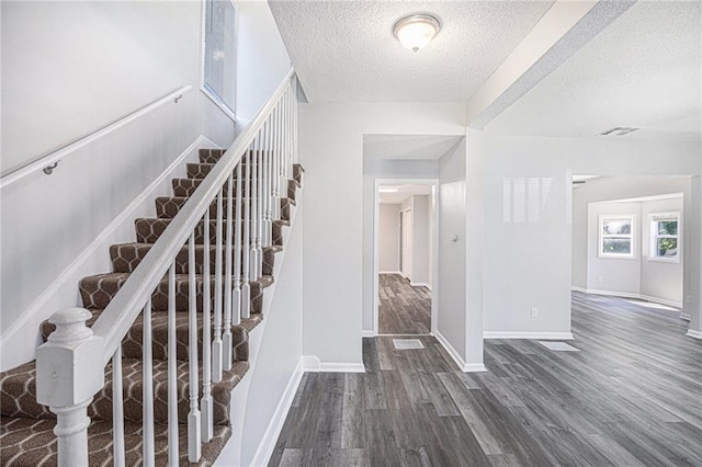 4937 Highland Ave, Kansas City, MO 64110 - stairs with a textured ceiling and wood finished floors