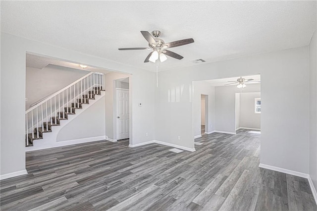 4937 Highland Ave, Kansas City, MO 64110 - unfurnished living room featuring a ceiling fan, wood finished floors, stairs, and a textured ceiling