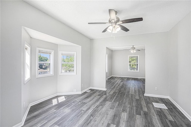 4937 Highland Ave, Kansas City, MO 64110 - spare room with dark wood-style floors, a ceiling fan, a textured ceiling, and attic access