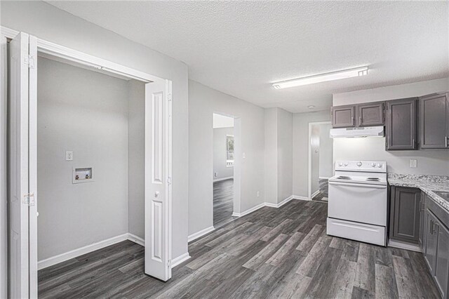 4937 Highland Ave, Kansas City, MO 64110 - kitchen with electric range, under cabinet range hood, dark wood-type flooring, and a textured ceiling