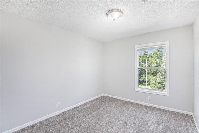 4937 Highland Ave, Kansas City, MO 64110 - carpeted spare room with baseboards and a textured ceiling