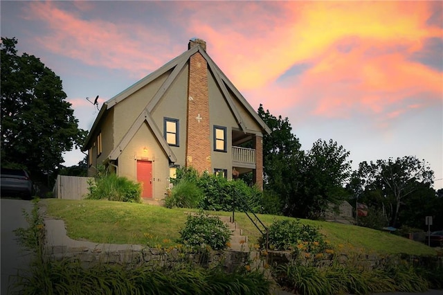 5024 Woodland Ave, Kansas City, MO 64110 - view of front of property featuring stucco siding, a balcony, and a chimney