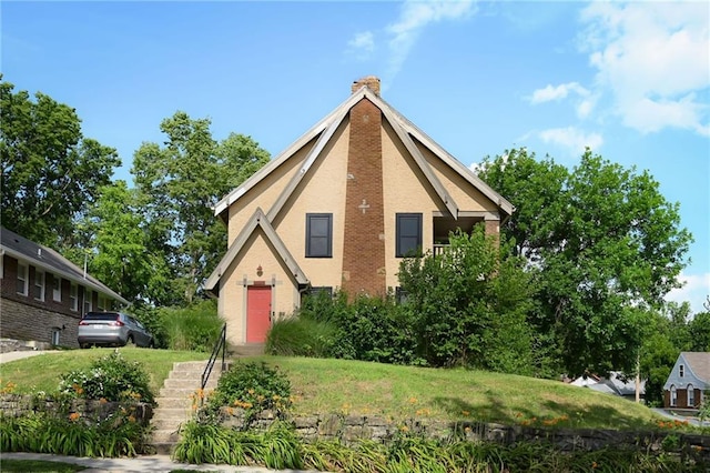 5024 Woodland Ave, Kansas City, MO 64110 - english style home featuring a chimney, a front yard, and stairway