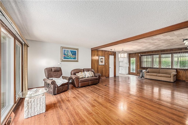 5919 N Adrian Ter, Kansas City, MO 64152 - living area featuring wood finished floors, a textured ceiling, and wood walls