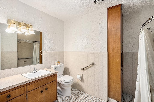 5919 N Adrian Ter, Kansas City, MO 64152 - bathroom featuring tile walls, vanity, a tile shower, a textured ceiling, and tile patterned floors