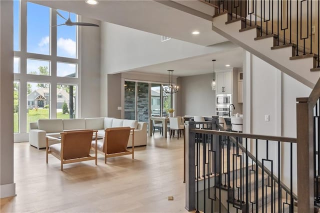 1113 Hummingbird Ct, Greenwood, MO 64034 - corridor with a towering ceiling, light wood-type flooring, recessed lighting, and a chandelier